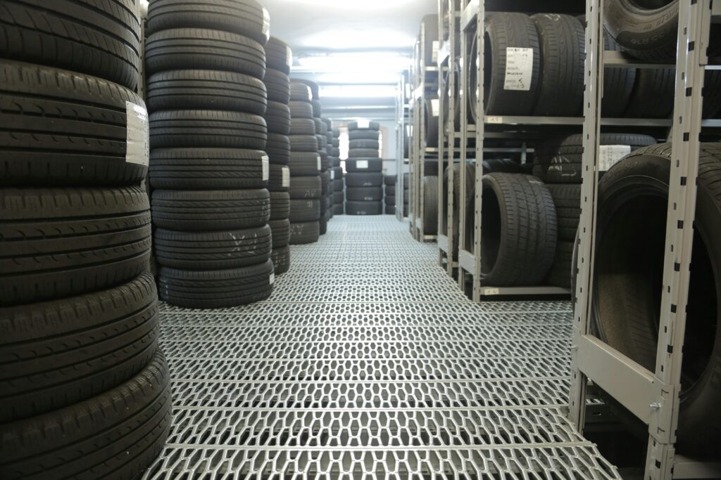 pexels photo 3806252 3806252 Rows of stacked tires in an indoor industrial warehouse for storage.